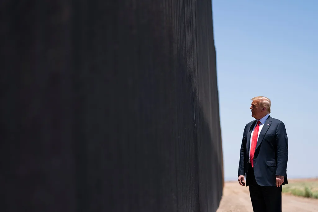 President Trump standing in front of the border wall