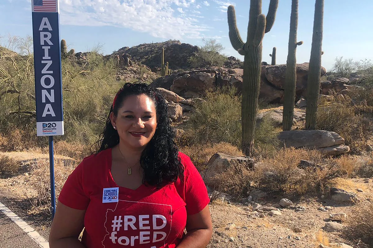 Marisol Garcia standing with Arizona signpost in front of desert landscape