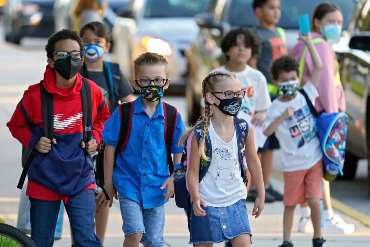 group of kids wearing backpacks and masks