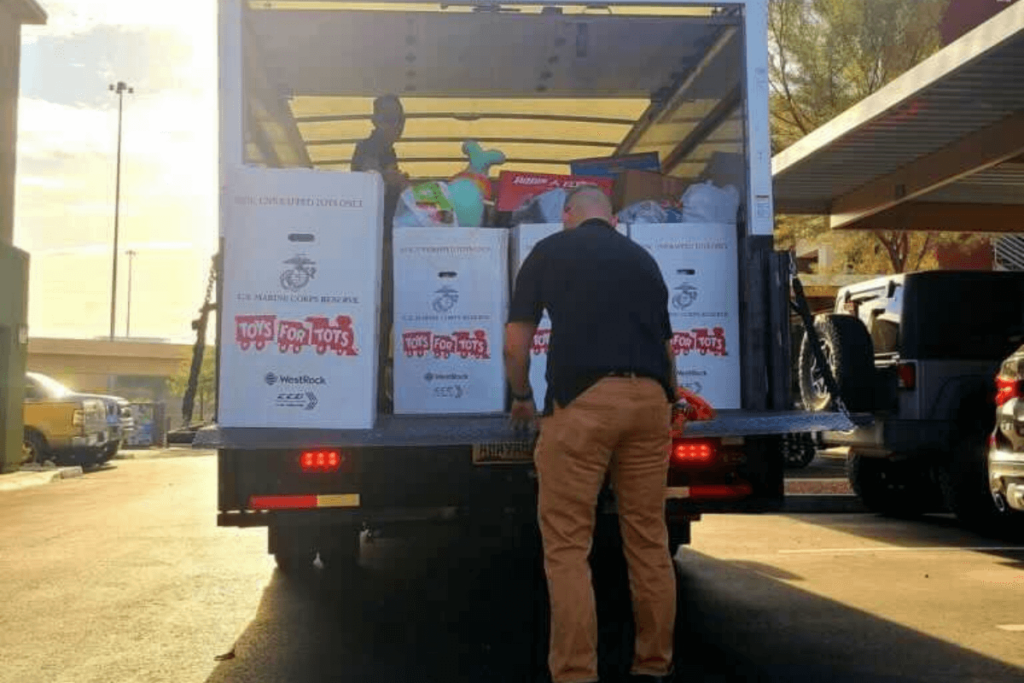 man loading boxes full of toys into moving truck