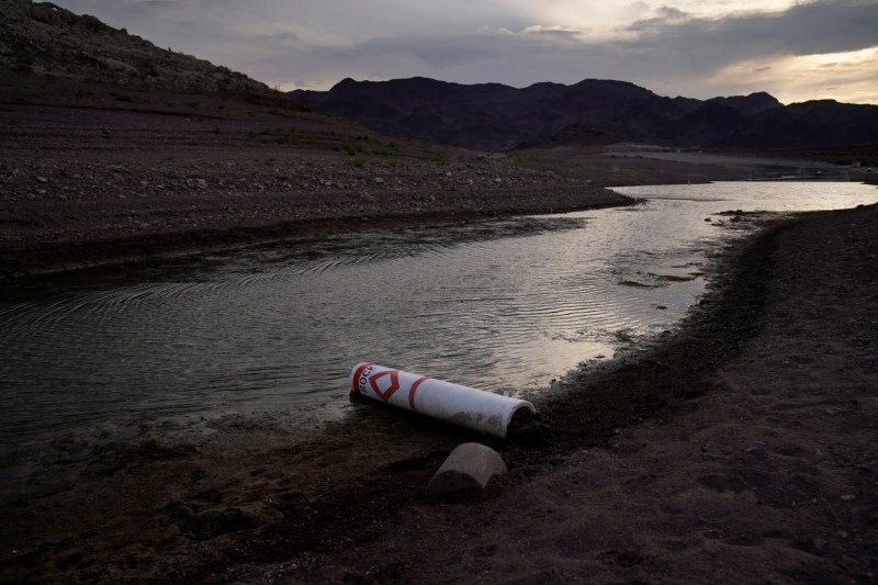 A stream of water surrounded by rock with a buoy laying half in the water