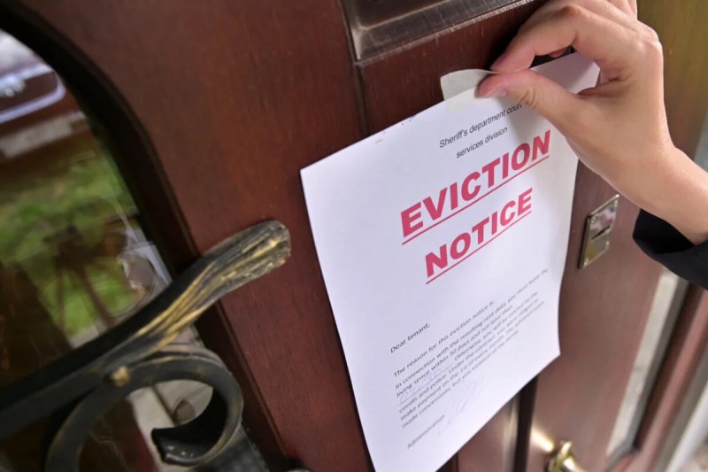 hand posting eviction notice to door