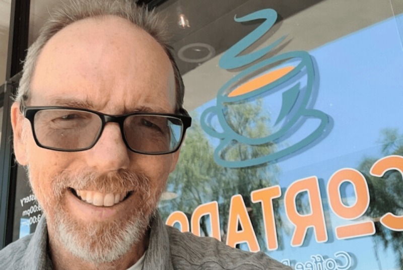 selfie of man in front of door with Cortado logo