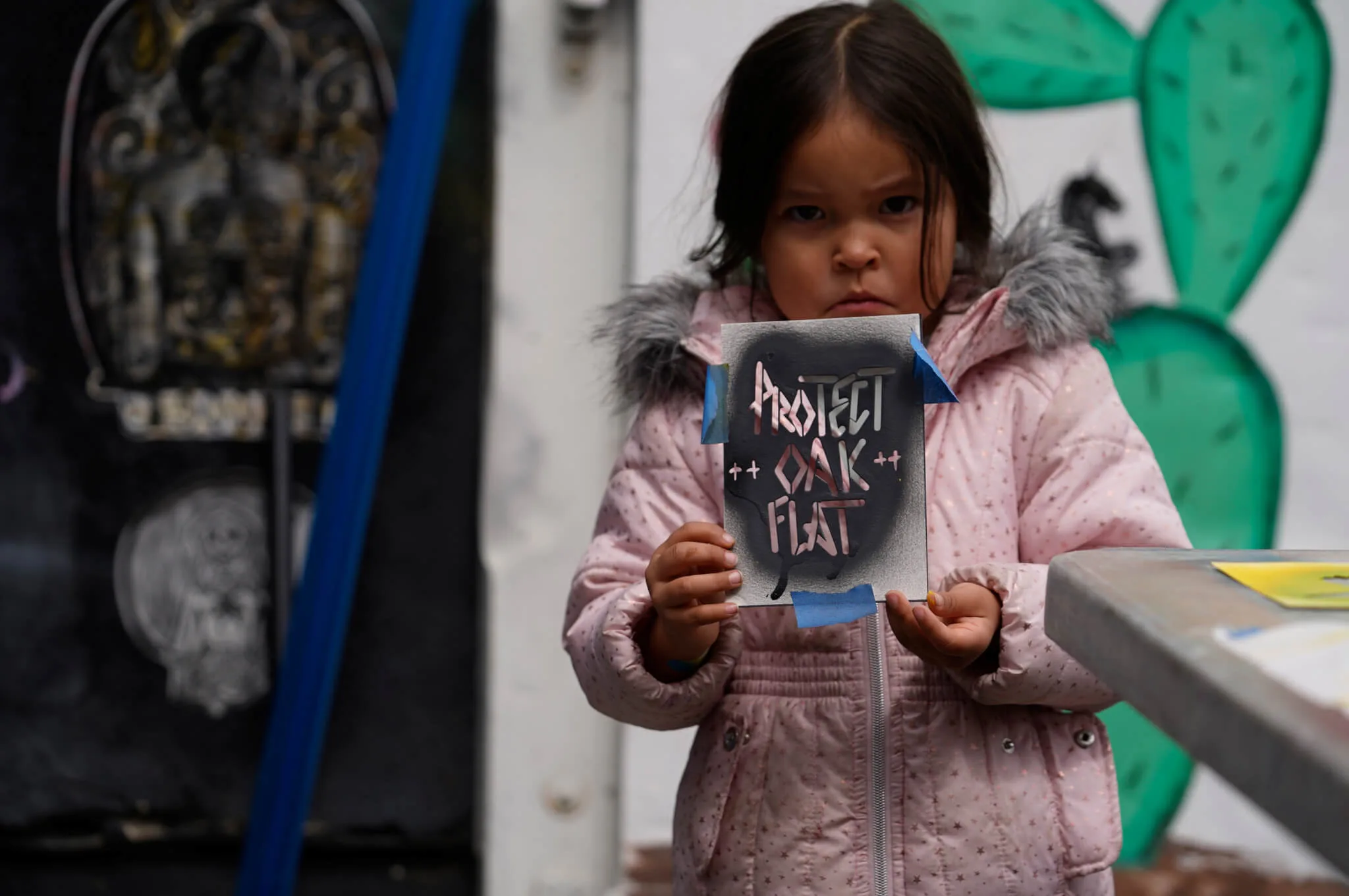 Apache Stronghold member Raetana Manny, 4, shows a sign to save Oak Flat, a site east of Phoenix that the group considers sacred, as she joined a gathering at Self Help Graphics & Art in the Los Angeles neighborhood of Boyle Heights on Monday, March 20, 2023. The Apache group battling a foreign mining firm that wants to build one of the largest copper mines in the United States on what tribal members say is sacred land will get a new chance to make its point Tuesday when a full federal appeals court panel takes another look at the case.