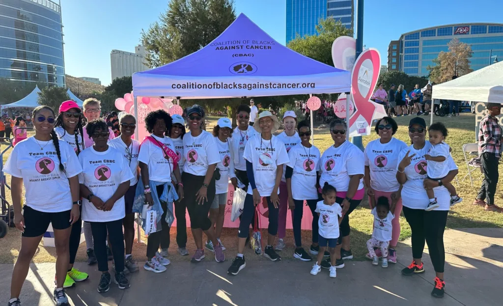 group of black women wearing matching Coalition of Blacks Against Cancer shirts under a tent