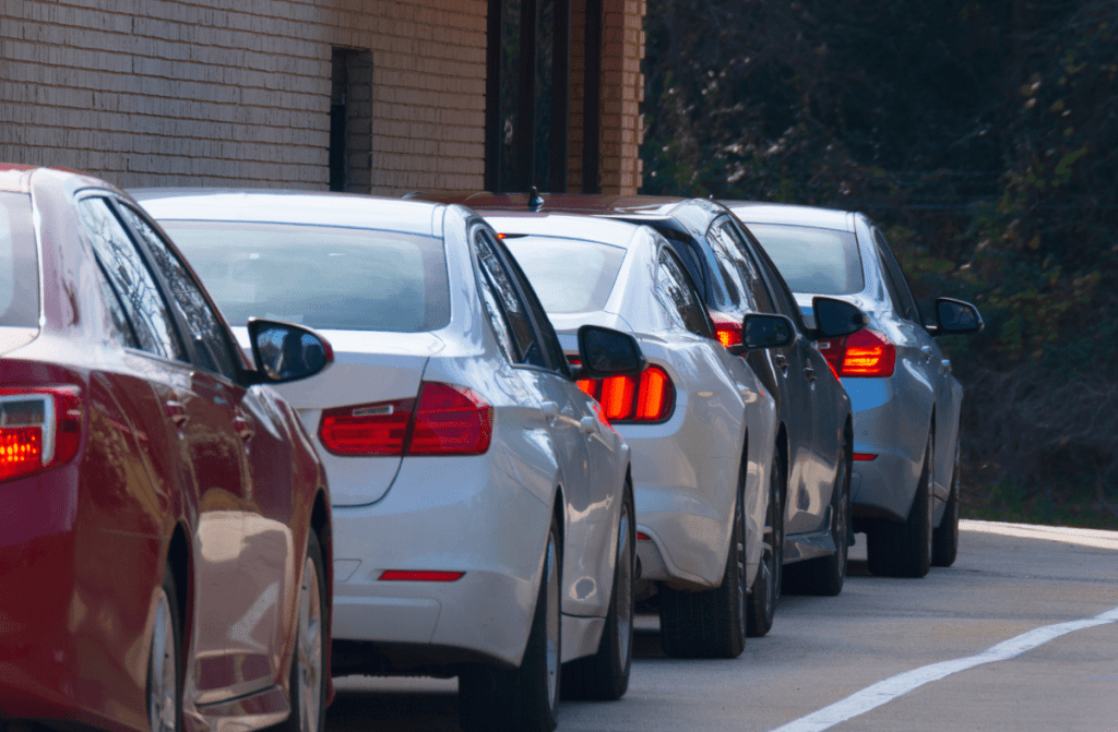 Line of cars idling at a drive-thru window.
