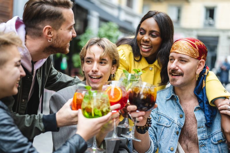 group of people toasting drinks at a bar