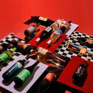 Bottles of wine lain on a red and black and white checkered display.