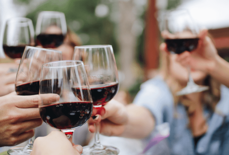 A group of friends clinking their wine glasses together.