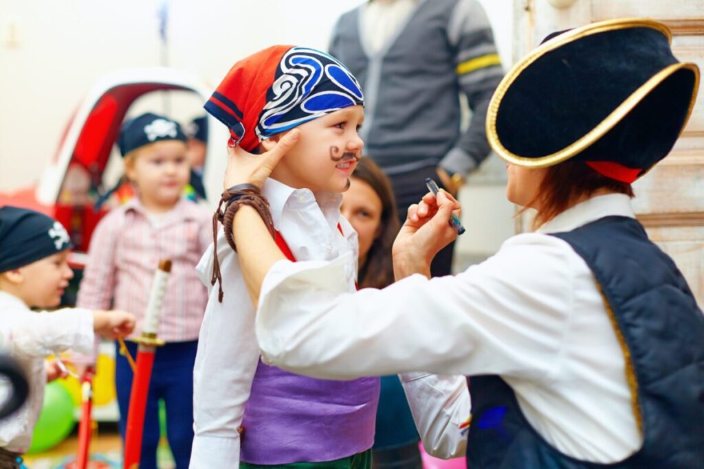 Woman painting a kid's face at a party.