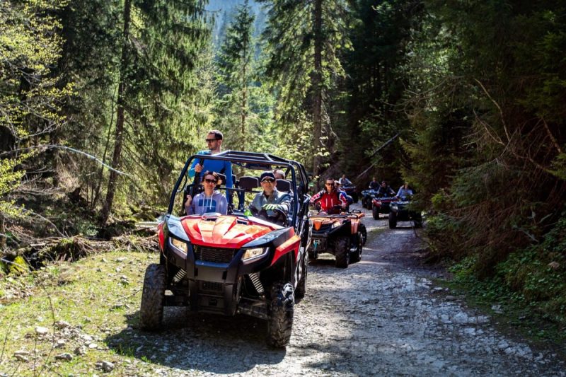 A tour group travels on ATVs and UTVs on the mountains
