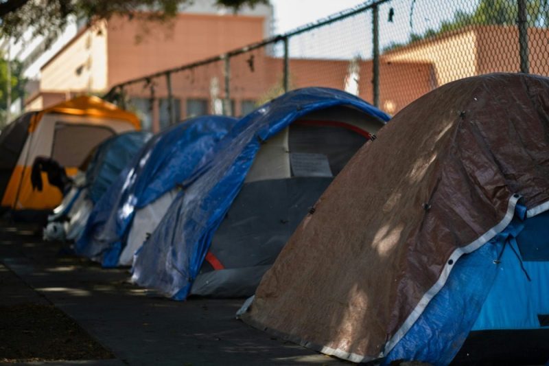 A row of tents lined up on the sidewalk.