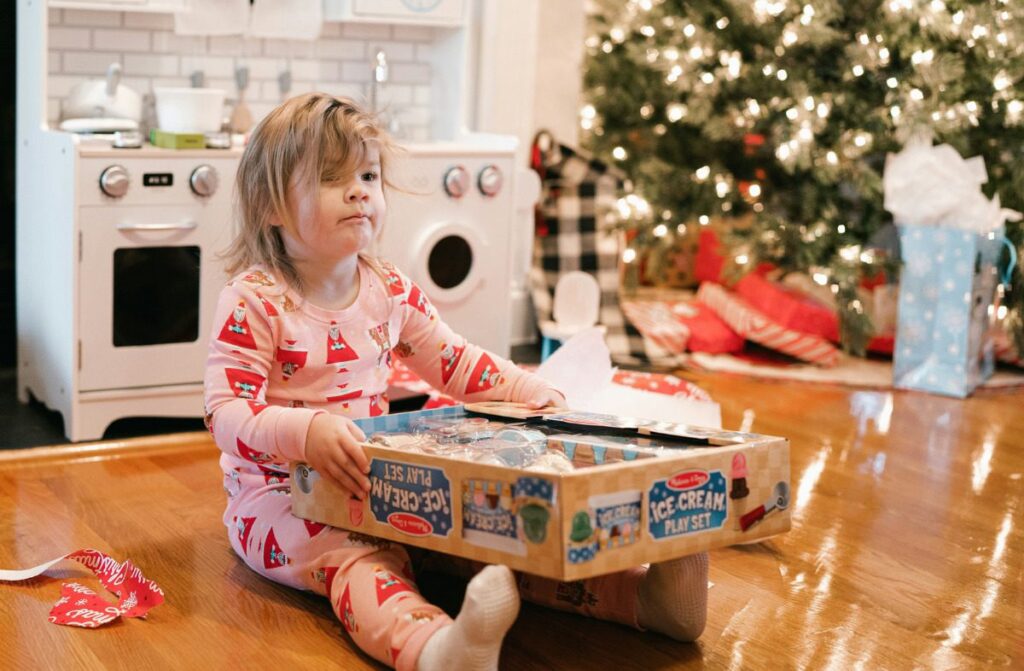 Young child opening a Christmas present.