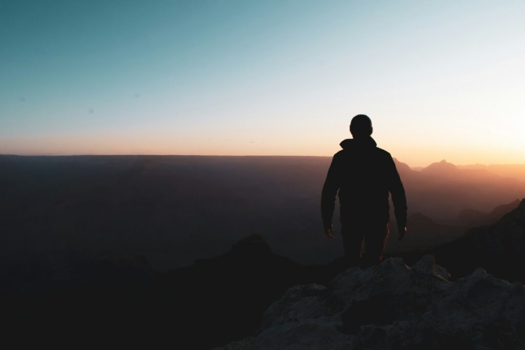 Silhouette of a man walking at dusk.