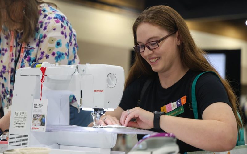 woman using sewing machine at QuiltCon