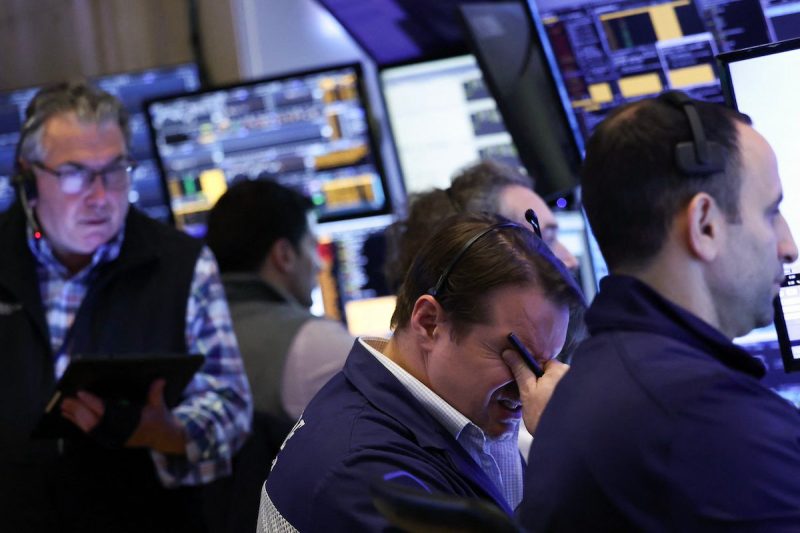 traders on the NYSE floor, one holding head in hands