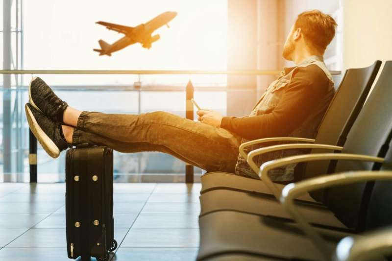 man waits for flight in an airport