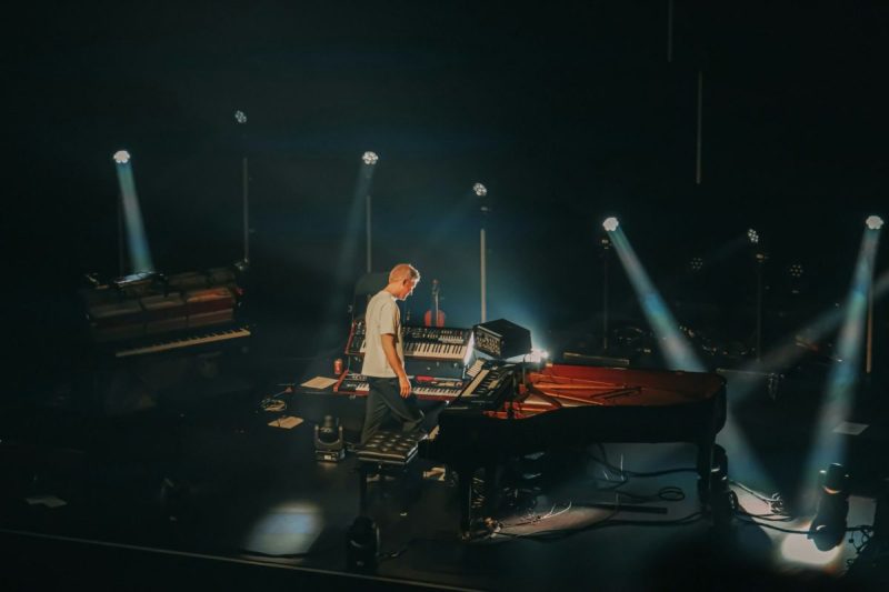 a pianist on stage under lights at the Flagstaff Piano Festival