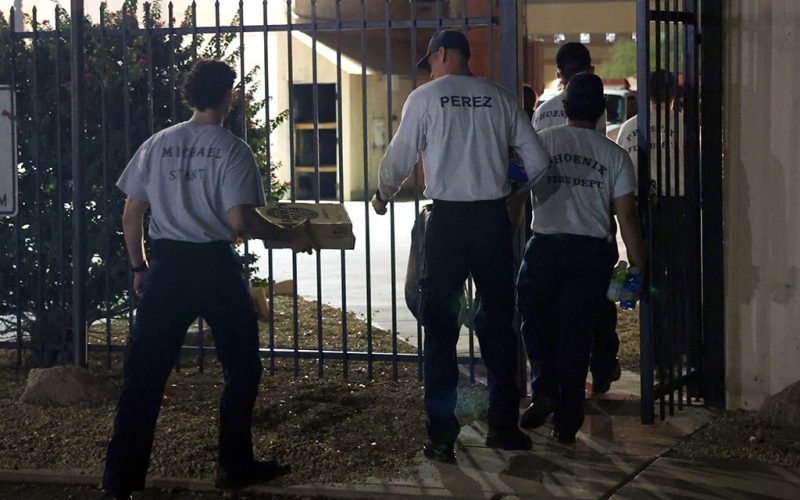 Phoenix Fire Department cadets walking through gate holding pizza boxes