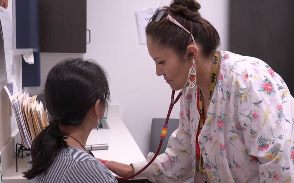 nurse placing stethoscope on patient's chest