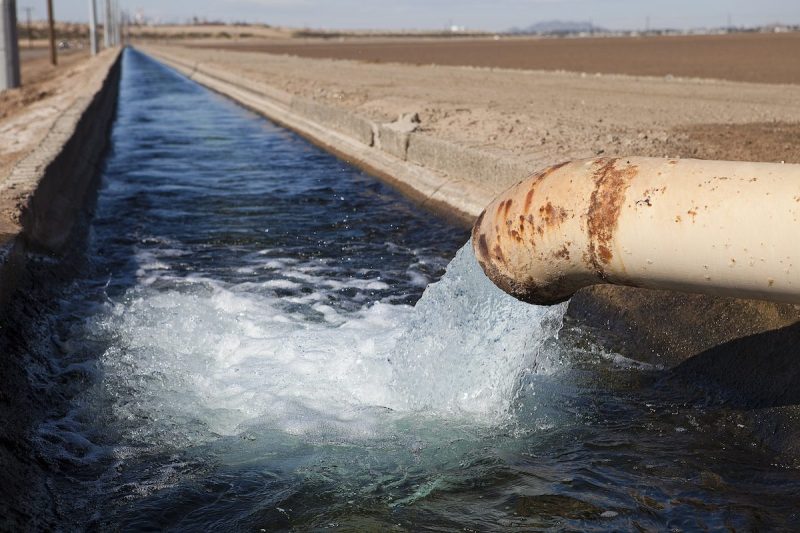 pipe pouring water into irrigation canal