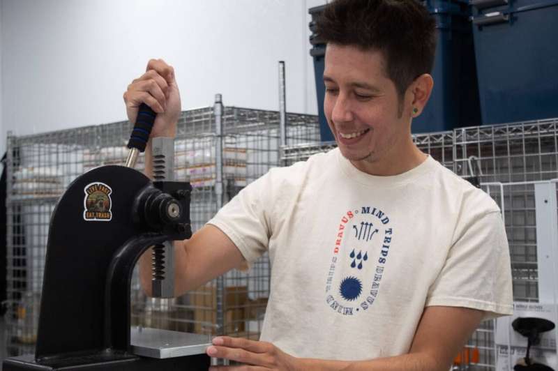 a man smiles behind a machine