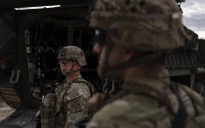 A man is halted climbing the US-Mexico border wall. Under new Trump rules, US troops sound the alarm