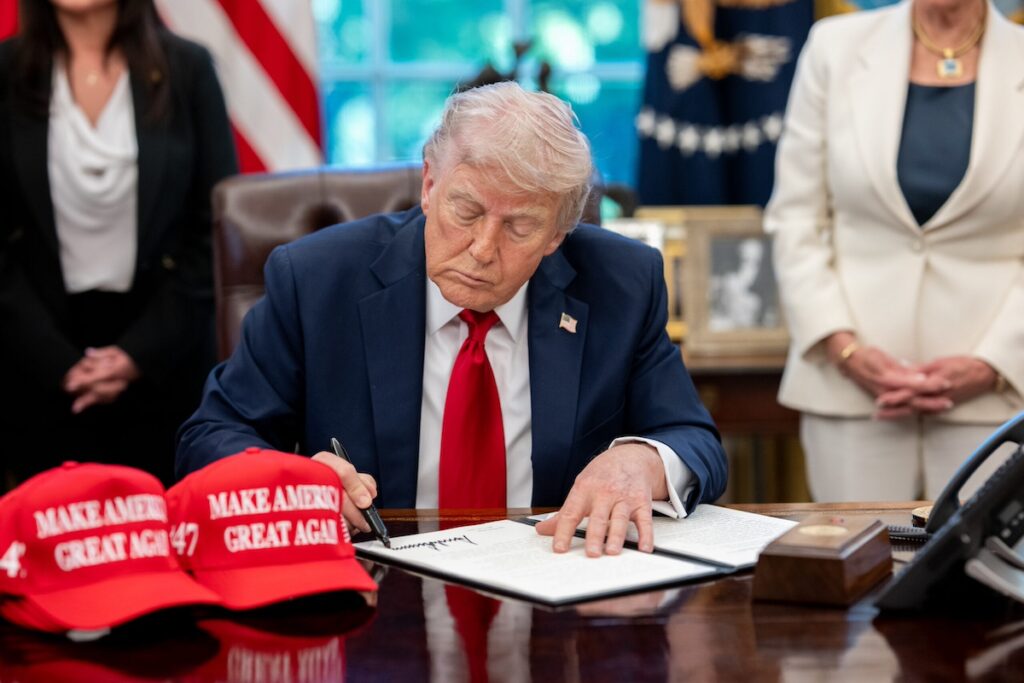 Trump signing executive orders at desk