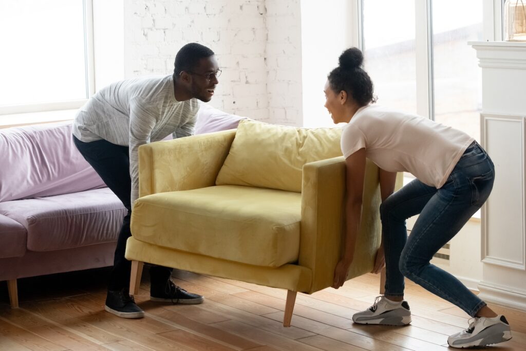 man and woman lifting chair together