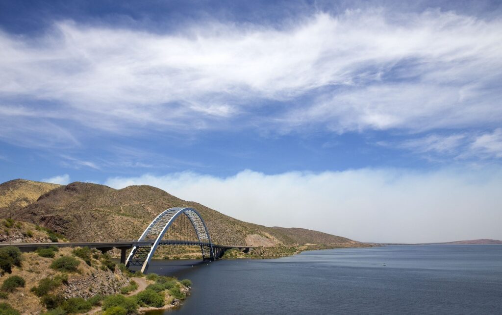 long bridge over water under blue sky