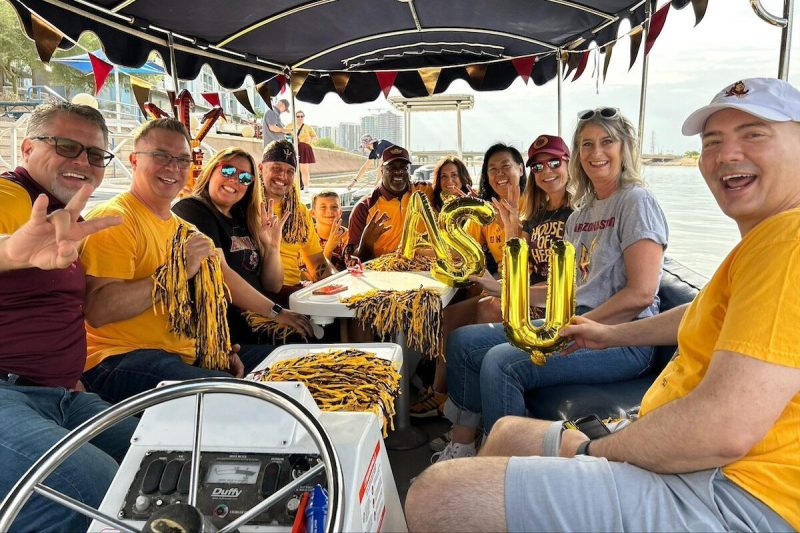 group of ASU football fans smiling on a boat