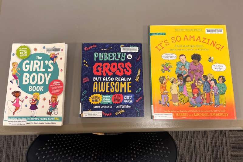 three children's books related to puberty laid on a table