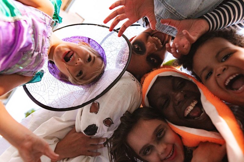 Children wearing Halloween costumes making funny faces