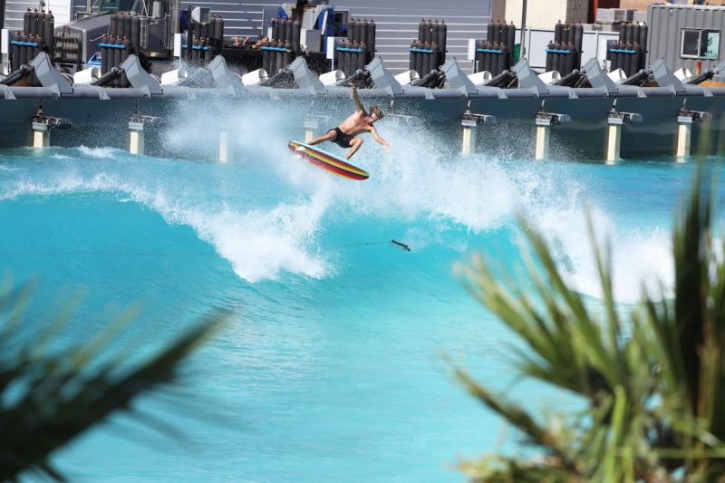 man surfing a wave while crowd watches