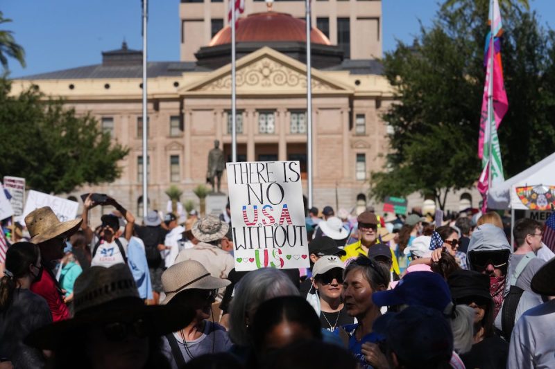 People protest Trump administration policies in front of the Arizona Capitol as part of a No Kings demonstration