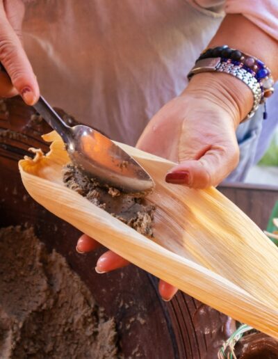 hands putting beans into a tamale