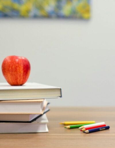books, an apple, pencils, and ABC blocks on a desk