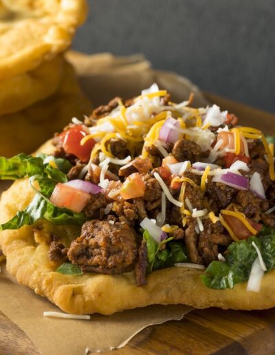 an Indian taco made with fry bread and topped with beef and veggies