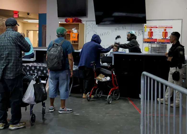 Clients of Keys to Change wait in line in the Lodestar Day Resource Center