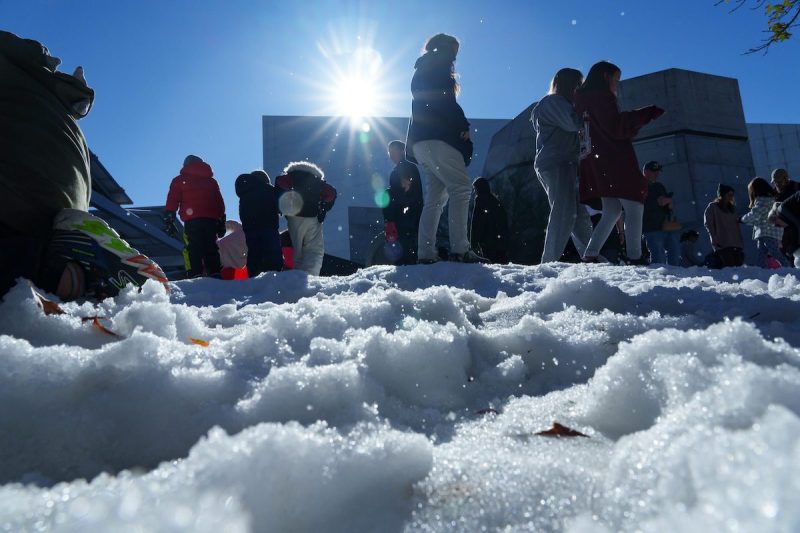 Kids and parents play in the snow outside the Arizona Science Center
