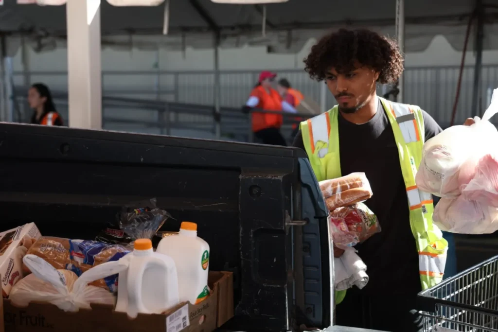 a man packs food boxes in a truck bed