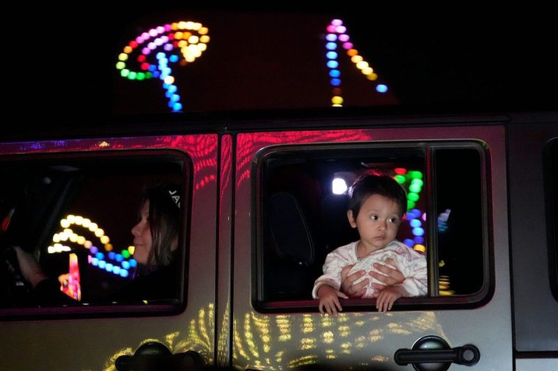 little boy looks out of car at Christmas lights