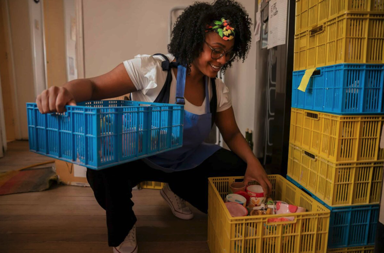 woman moving cans in crates