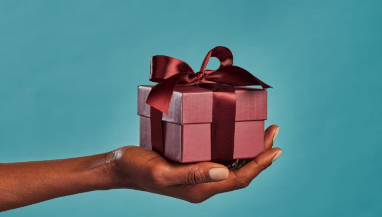 a hand holding a small gift box