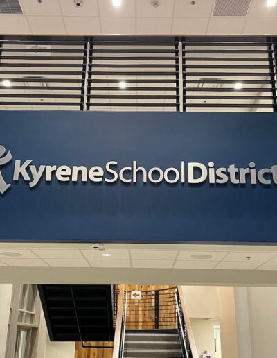 a sign that says Kyrene School District on a wall between two floors