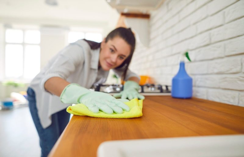 woman cleaning a kitchen counter with a cloth