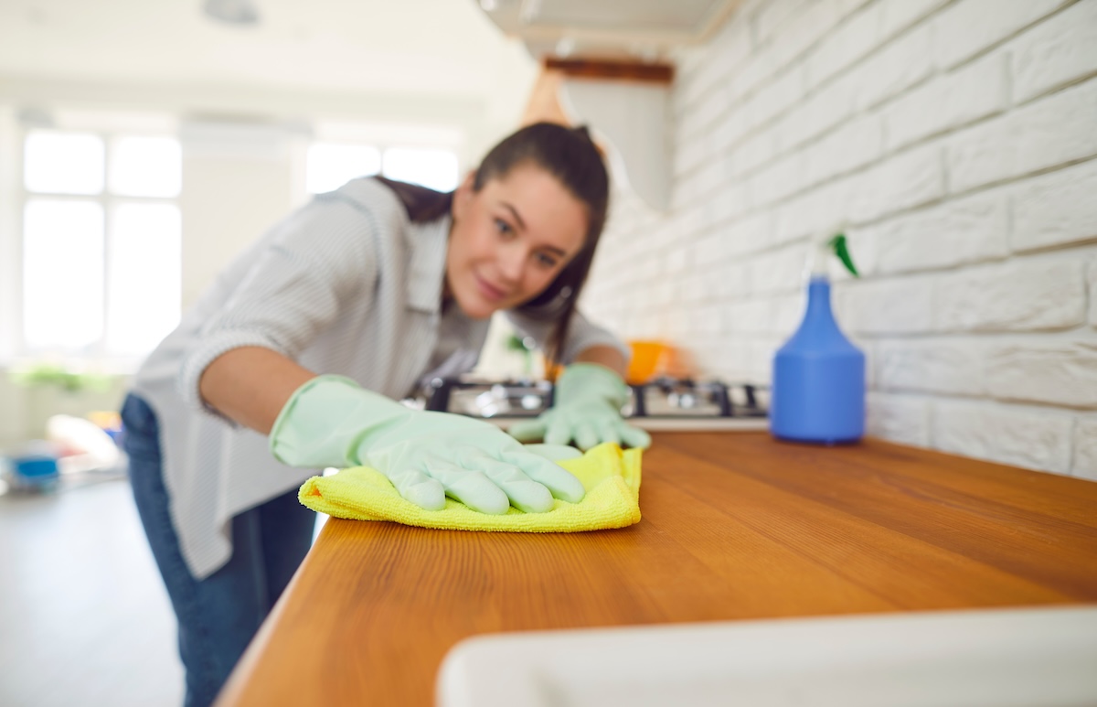 woman cleaning her countertop with a cloth