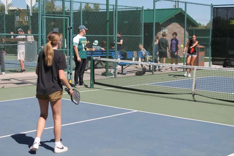 two high schools playing pickleball on a court