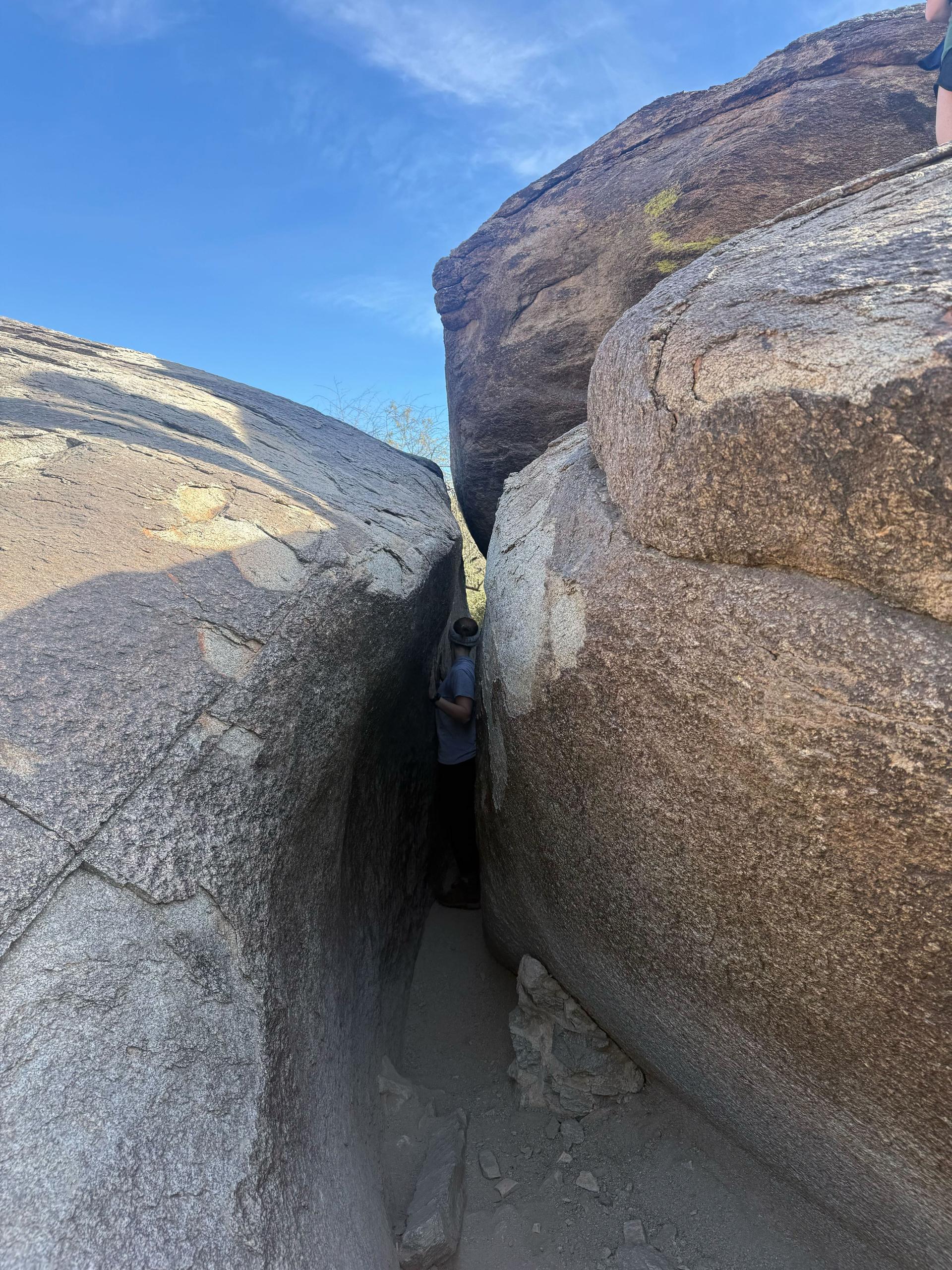hiker sliding between two big rocks
