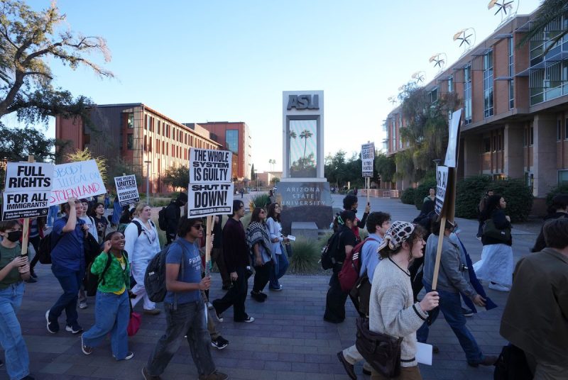 people marching with pro-immigrant and anti-ICE signs